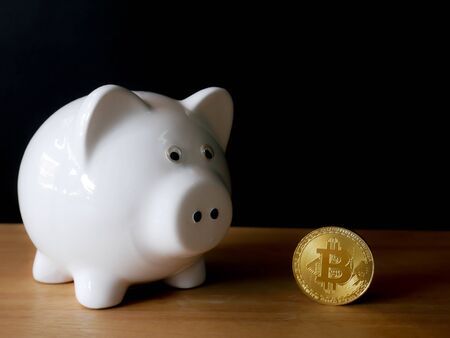 pot full of gold coins on a wooden surface and dark backgroundの写真素材