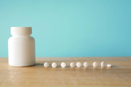 medical pills on blue background, bottle of pillsの写真素材
