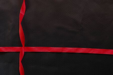 red ribbon and black silk satin texture, cotton fabric backgroundの写真素材