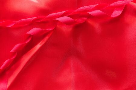 red ribbon and red silk satin texture, cotton fabric backgroundの写真素材