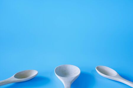 wooden spoon on blue background.の写真素材