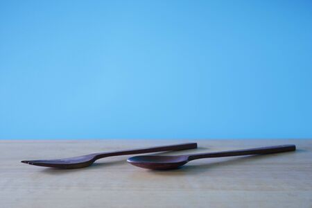 wooden spoon and fork on blue background.の写真素材