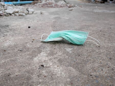 used surgical mask on the floor. discarded face maskの写真素材