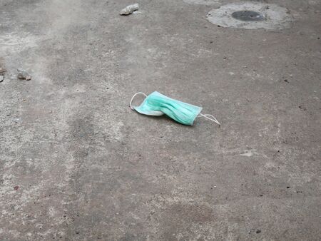 used surgical mask on the floor. discarded face maskの写真素材