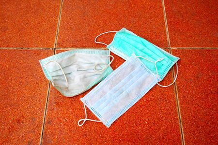 dirty surgical mask on the floor. discarded face mask.の写真素材