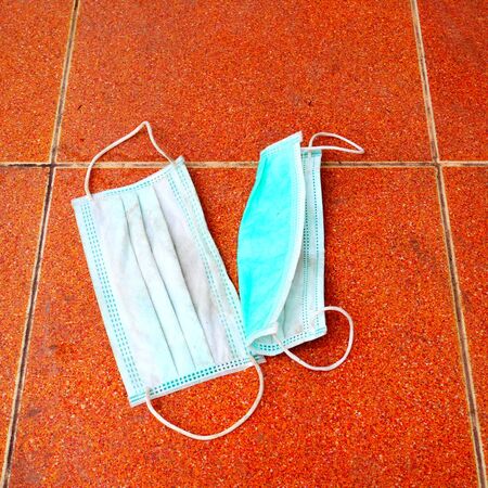 dirty surgical mask on the floor. discarded face mask.の写真素材