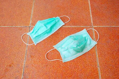 used surgical mask on the floor. discarded face mask.の写真素材