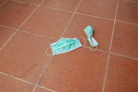 used surgical mask on the floor. discarded face mask.の写真素材