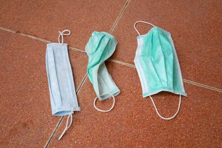 used surgical mask on the floor. discarded face mask.の写真素材