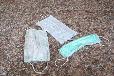 used surgical mask on the floor. discarded mask concept corona virusの写真素材
