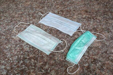 used surgical mask on the floor. discarded mask concept corona virusの写真素材
