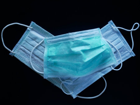 Medical protective mask on blue background. Disposable surgical face mask cover the mouth and nose.