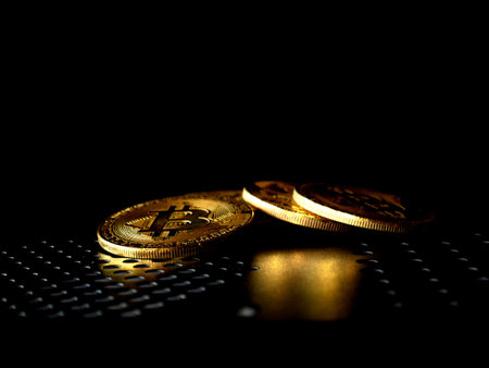 Close up of gold bitcoin on black background with selective focus
