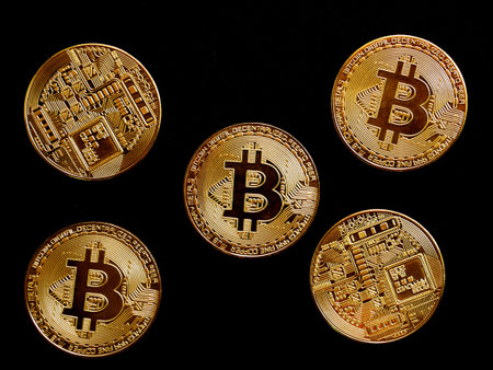 Close up of gold bitcoin on black background with selective focus