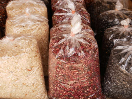 brown rice and white rice in transparent plastic bag isolated on white background.の写真素材