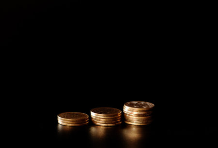 stacks of gold coin on black background concept saving money