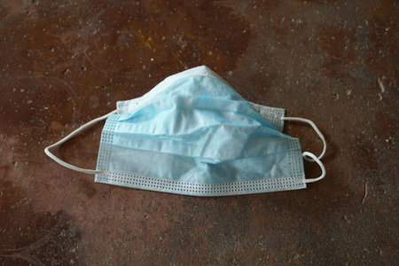 discarded used surgical mask on the floor. discarded mask after concept virus fever.