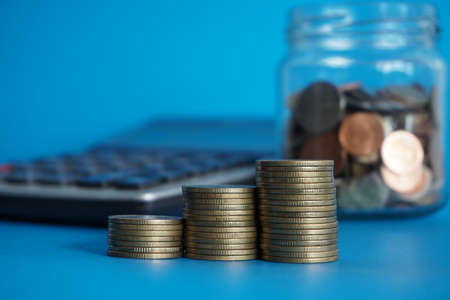 stacks of money coin with calculator, Business and financial investment concept blur backgroundの写真素材