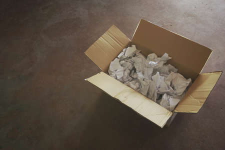 Opened cardboard box on concrete floorの写真素材