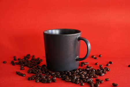 cup of coffee with beans on red backgroundの写真素材