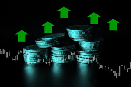 Coins stacks on dark background with green arrows. Business and finance concept.の写真素材