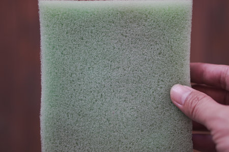 Sponge for washing dishes in the hands of a man close-upの写真素材