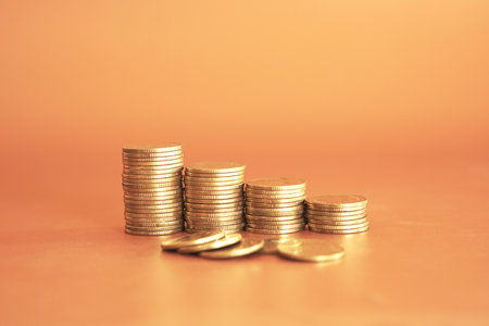 Stack of coins on orange background, business and finance concept idea.の写真素材