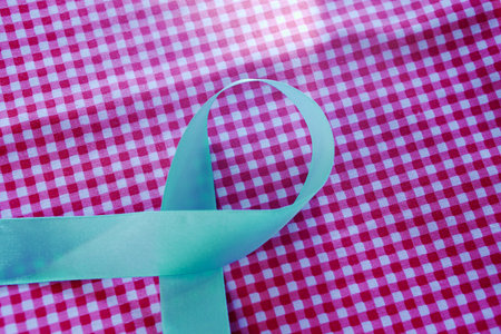 Aids Awareness Ribbon. Blue Ribbon on Pink Background. Cancer Awareness Month.の写真素材