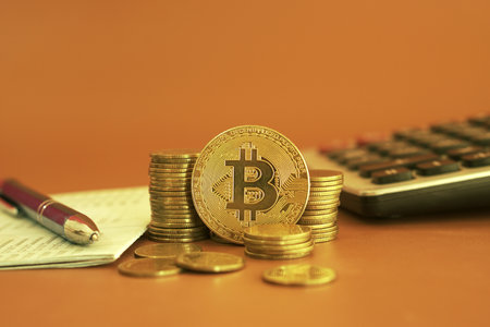 bitcoin and calculator on orange background, Cryptocurrency and finance conceptの写真素材