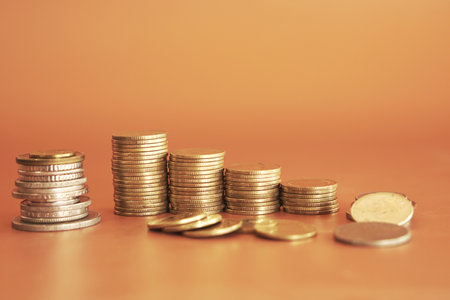Coins stack on orange background, business and finance concept idea.の写真素材