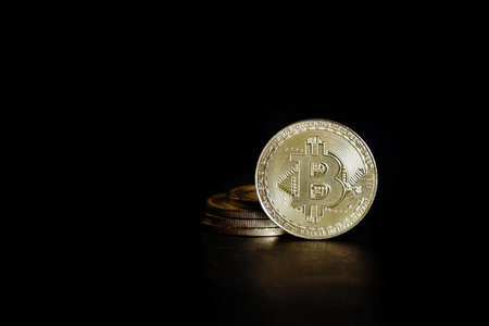 Golden bitcoin coin on black background. Cryptocurrency and finance concept.の写真素材