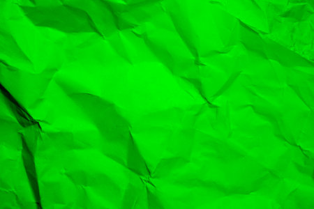 Green creased crumpled paper background grunge texture backdrop.の写真素材