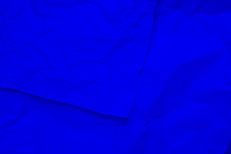 Blue creased crumpled paper background grunge texture backdrop.の写真素材