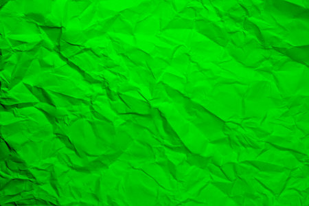 Green crumpled paper background. Wrinkled paper texture.の写真素材