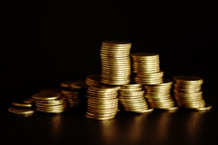 Stacks of gold coins on black background, business and finance conceptの写真素材