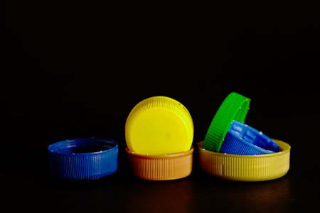 Colorful plastic bottle caps on black background, shallow depth of fieldの写真素材