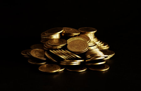 Pile of gold coins on black background, business and finance concept idea.の写真素材