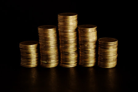 Stacks of golden coins on black background. Business and finance concept.の写真素材