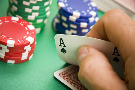 Poker player turning over an ace in his hand