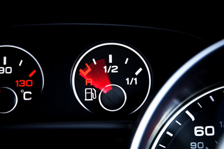 Empty fuel gauge on a black dashboard