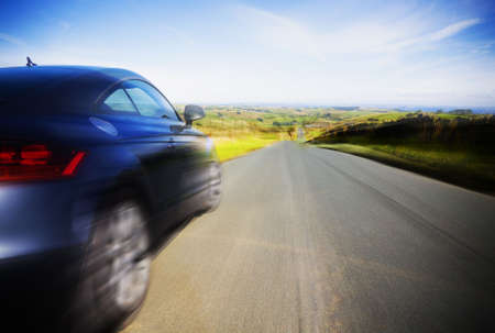 Blurred motion of sports car on country roadの写真素材