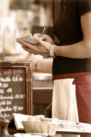 Toned outdoor cafe scene with waitress taking orderの写真素材