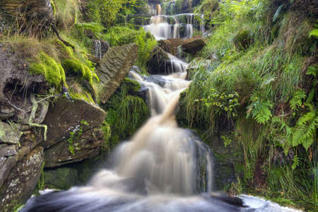 Mountain stream waterfall cascading over rocksの写真素材