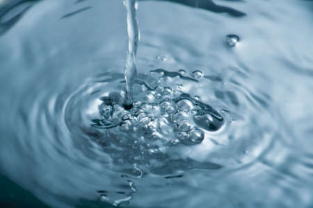 Water being poured producing bubbles and ripplesの写真素材