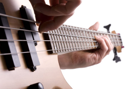Close up of bass guitar fretboard with musicians hand