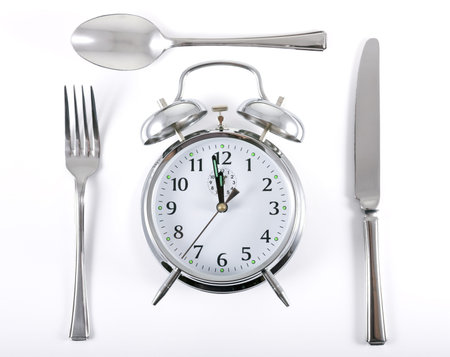 Alarm clock with knife fork and spoon for mealtime concept