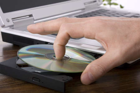 Loading a CD or DVD into a laptop computerの写真素材