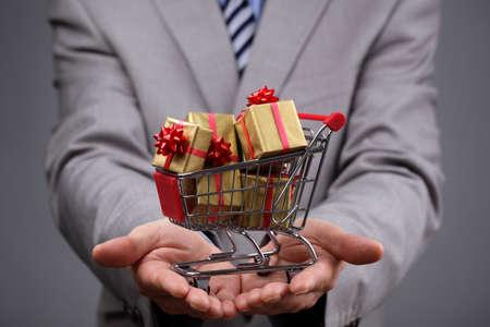 Businessman with shopping cart full of gift boxes concept for gift shopping, business gift, christmas or valentine's day giftの写真素材