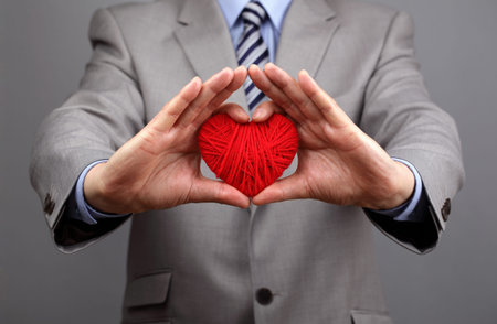 Man holding a red woolen heart concept for valentine's day, business customer care, charity, social...