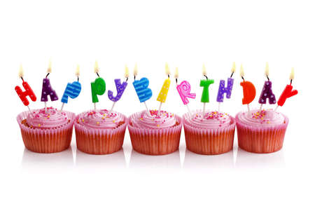 Happy birthday candles on pink cupcakes isolated on whiteの写真素材